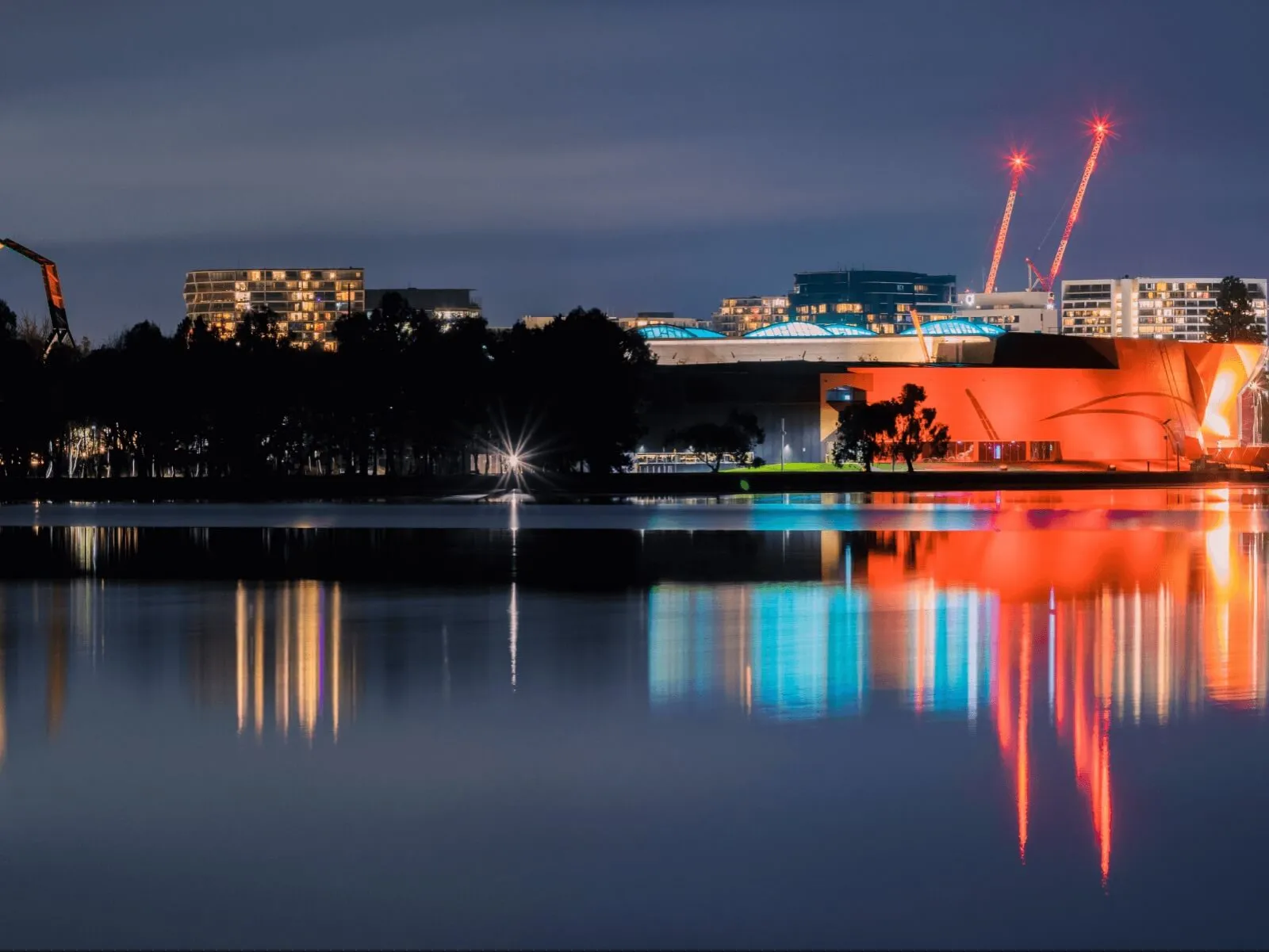 The National Museum of Australia lit up at night and reflected in Lake Burley Griffin.
