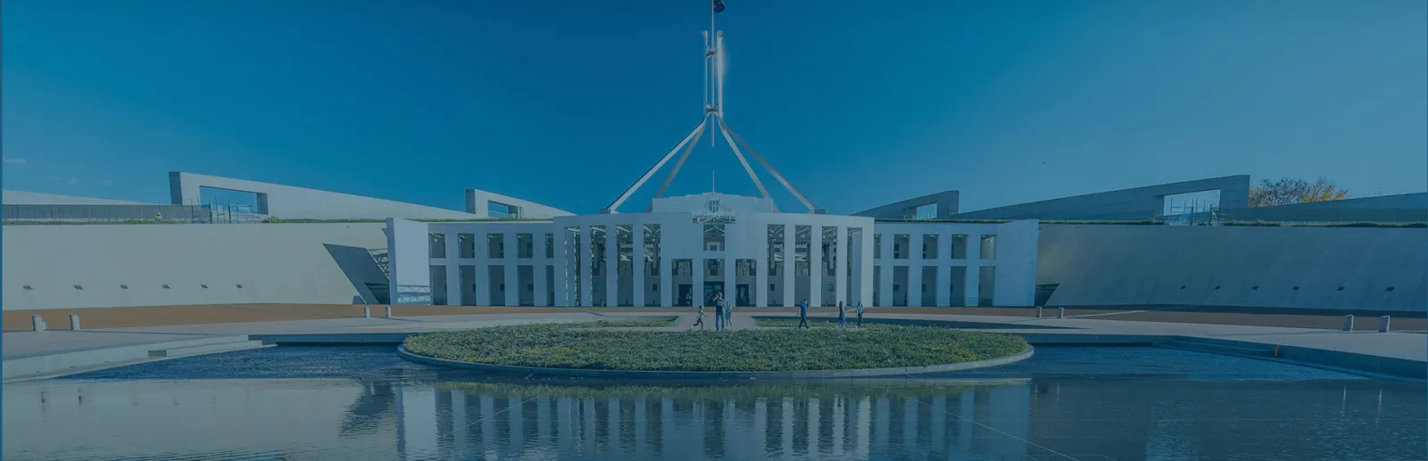 Parliament House, Canberra, with its flag mast above the forecourt pool