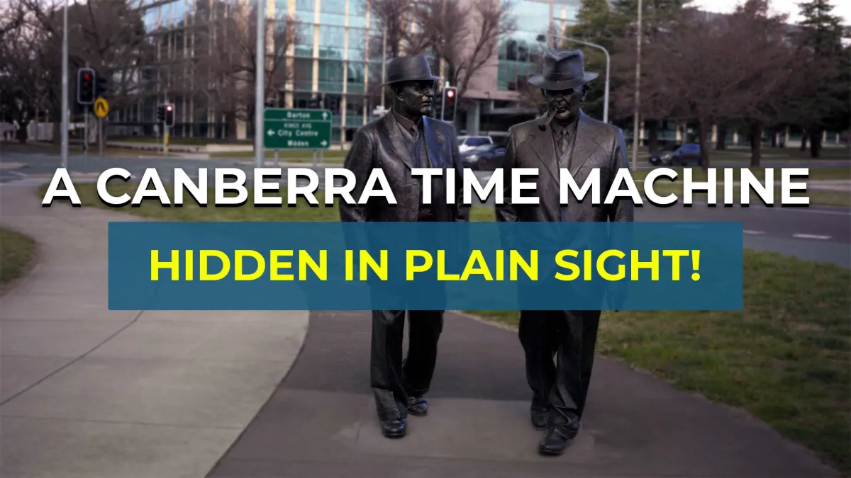 Two bronze life‑size statues of men in suits and hats walking on a city footpath with office buildings and traffic lights behind them, overlaid by bold text reading A CANBERRA TIME MACHINE and a blue banner saying HIDDEN IN PLAIN SIGHT!